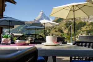 a table with a cup of coffee on top at Hotel Alpenroyal in Zermatt
