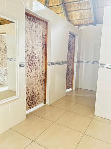 um quarto com paredes brancas e pisos em azulejo em THE GALAXY FOREST LODGE em Manguzi
