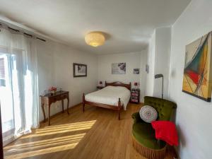 een slaapkamer met een bed, een stoel en een tafel bij Home Away From Home in Évora