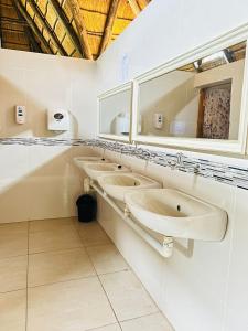 a bathroom with three sinks and a mirror at THE GALAXY FOREST LODGE in Manguzi