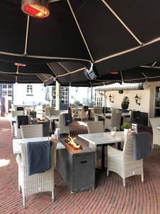 restauracja ze stołami, krzesłami i parasolem w obiekcie Stijlvol Chalet Lathum w mieście Lathum