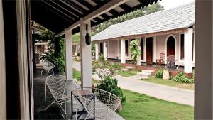 Blick auf eine Terrasse mit Stühlen und ein Haus in der Unterkunft Lahe by Loka in Auroville