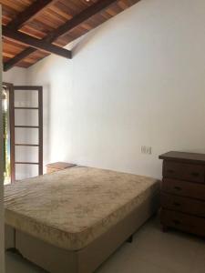 ein Schlafzimmer mit einem großen Bett und einer Holzkommode in der Unterkunft CASA DE PRAIA BOIÇUCANGA 5 Quartos PISCINA, SAUNA, CHURRASQUEIRA in São Sebastião + 39 Fotos