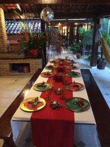 ein langer Tisch mit Tellern voller Essen darauf in der Unterkunft CASA DE PRAIA BOIÇUCANGA 5 Quartos PISCINA, SAUNA, CHURRASQUEIRA in São Sebastião
