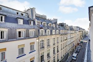 una fila di edifici su una strada di città di Pick A Flat's Apartements in Louvre-Rivoli - Rue du Roule a Parigi