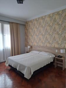 Un dormitorio con una cama grande y una pared en HOTEL REGIS en Buenos Aires