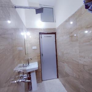 a bathroom with a sink and a white door at A K CONTINENTAL in Rānchī