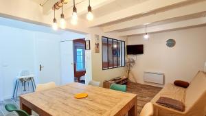 ein Wohnzimmer mit einem Holztisch und einer Couch in der Unterkunft Jolie maison avec cour dans le centre du village in La Couarde-sur-Mer