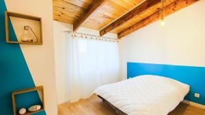 ein Schlafzimmer mit einem weißen Bett und einer blauen Wand in der Unterkunft Jolie maison avec cour dans le centre du village in La Couarde-sur-Mer