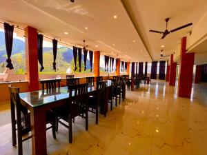 uma sala de jantar com uma mesa longa e cadeiras em Hotel The SSB - Property of the Year ! Luxury Balcony Rooms ! Mountain View ! Rooftop Cafe ! Big Parking ! em Mussoorie