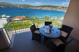 una mesa en un balcón con vistas al agua en Apartments Kelić, en Trogir
