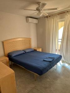 1 dormitorio con 1 cama azul y ventilador de techo en Seaside House, bellísima casa en Marbella en Marbella