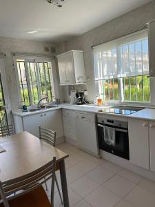 cocina con electrodomésticos blancos, mesa, mesa y sillas en Seaside House, bellísima casa en Marbella en Marbella