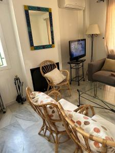 sala de estar con sillas, sofá y TV en Seaside House, bellísima casa en Marbella en Marbella