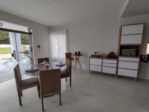 uma sala de estar com mesa e cadeiras e uma cozinha em Lar das Cerejeiras em Bananeiras