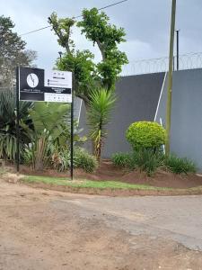 a sign on the side of a road with plants at Adante Lodge & Conferencing in Mthatha