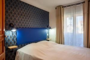 a bedroom with a bed with a blue headboard and a window at Studio hypercentre Marseille in Marseille