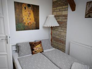 um quarto com um sofá com um candeeiro e um quadro em Kisfaludy Károly Apartman em Gyor