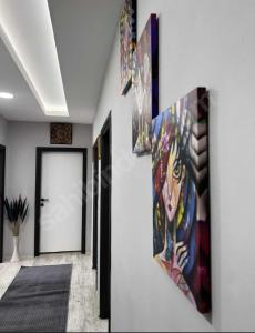 a hallway with paintings on the wall and a door at 9 Otel Samsun in Kalkanlı
