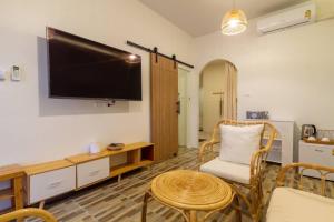 a living room with a flat screen tv on the wall at Tawaen Beach Villa in Ko Larn
