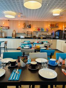 ريسيدوم تولوز تولوزا في تولوز: غرفة طعام مع طاولة وكراسي مع أطباق عليها