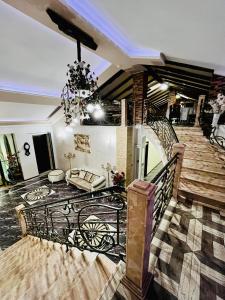 ein Wohnzimmer mit einer Treppe und einem Kronleuchter in der Unterkunft Lux Palace Hotel in Kutaissi