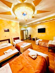 una camera con tre letti e un soffitto di Lux Palace Hotel a Kutaisi