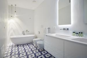 a bathroom with a tub and a sink and a toilet at Hotel Scalinatella in Capri