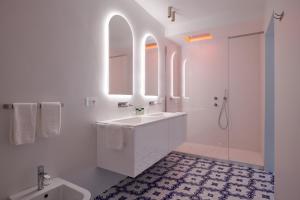 a white bathroom with a sink and a shower at Hotel Scalinatella in Capri
