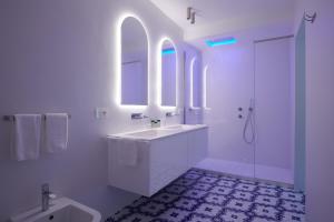 a white bathroom with a tub and a sink at Hotel Scalinatella in Capri