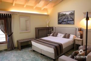 ein Schlafzimmer mit einem großen Bett und einem Sofa in der Unterkunft Castrum Wine Relais in San Pietro in Cariano