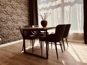 a dining room table with chairs and a vase on it at CASA REHSE I Loft-Apartment mit Gartenblick I kostenlos Parken & WLAN I Self-Check-in I 55Zoll-Smart&Kabel-TV I ÖPNV in Erfurt