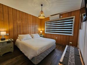 Un dormitorio con una cama grande y una ventana en Casa Ellies Hotel Boutique, en Puerto Varas