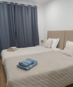 two beds with towels sitting on top of them at Mondalva Apartamentos in São Pedro de Alva