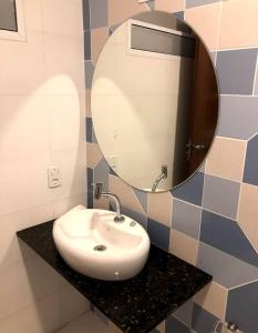 a bathroom with a sink and a mirror at GVR Praia Hostel in João Pessoa