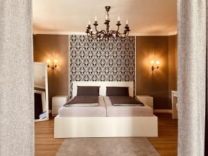 a bedroom with a white bed and a chandelier at CASA REHSE I Stilvolles Apartment I 24h-Self-Check-in I kostenlos Parken & WLAN I 55-Zoll-Smart&Kabel-TV I ÖPNV in Erfurt