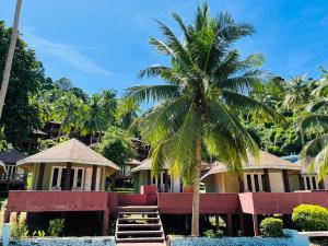 una palma di fronte a un edificio di Koh Ngai Resort a Ko Ngai