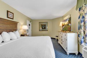 Cette chambre comprend un grand lit et une télévision. dans l'établissement Compass Cove Resort 1052, à Myrtle Beach