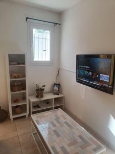 a room with a flat screen tv on the wall at Maison au cœur du Pic Saint Loup in Sainte-Croix-de-Quintillargues