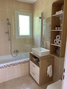 La salle de bains est pourvue d'un lavabo et d'une baignoire. dans l'établissement Maison au cœur du Pic Saint Loup, à Sainte-Croix-de-Quintillargues