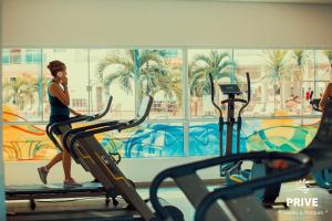 une femme qui roule sur un tapis de course dans une salle de sport dans l'établissement Riviera Park Caldas Novas, à Caldas Novas