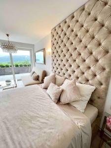 a large bed in a bedroom with a large headboard at Jollien apartmán Gold in Námestovo