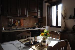 a kitchen with a table with a vase of flowers on it at BB Casavacanze Corneto in Bomba