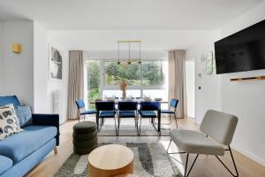 salon z niebieską kanapą i stołem w obiekcie Incroyable appartement - 3BR-8P - Pl de la Nation w Paryżu