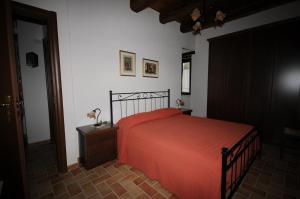 1 dormitorio con 1 cama con colcha roja en BB Casavacanze Corneto en Bomba