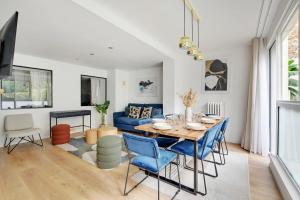 une salle à manger avec une table et des chaises bleues dans l'établissement Chic 3-Bedroom Parisian Apartment in Vibrant Vincennes, à Paris