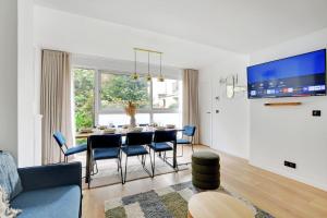 een woonkamer met een tafel en blauwe stoelen bij Chic 3-Bedroom Parisian Apartment in Vibrant Vincennes in Parijs