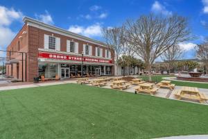 un groupe de tables de pique-nique et de bancs devant un bâtiment dans l'établissement 2 Bedroom Loft @ Grand Strand Brewery 205, à Myrtle Beach