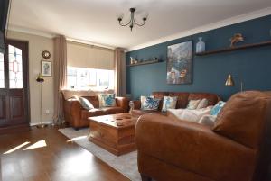 a living room with a couch and a coffee table at Snaffles a family friendly holiday cottage in Rye Harbour