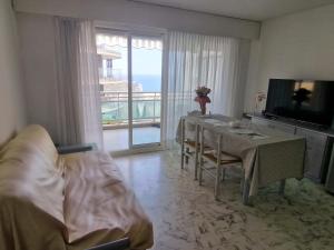 a living room with a dining table and a television at 1 meter from Monaco. 5 min by elevators to Larvotto beach. in Beausoleil